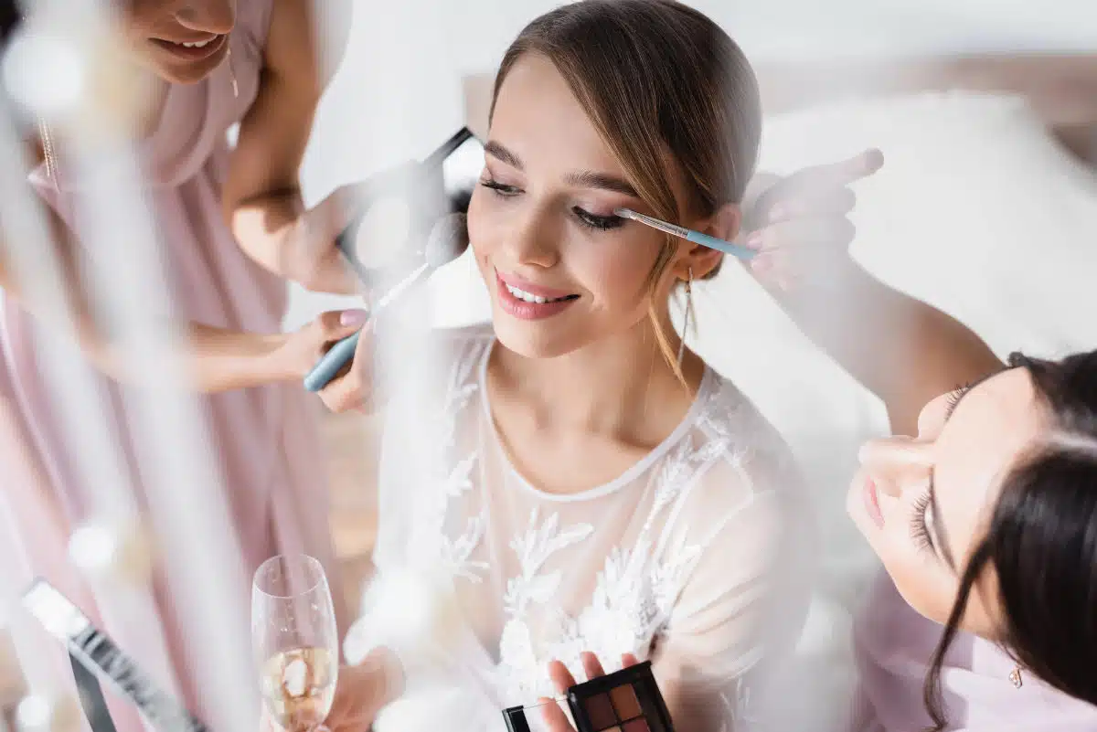 Une future mariée en train de se faire maquiller