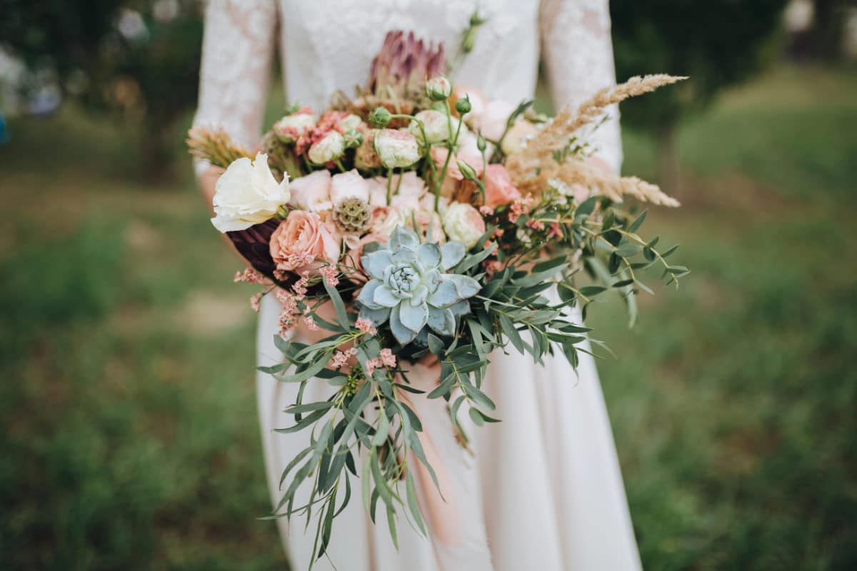 Une mariée avec un bouquet de fleurs de mariage champêtre