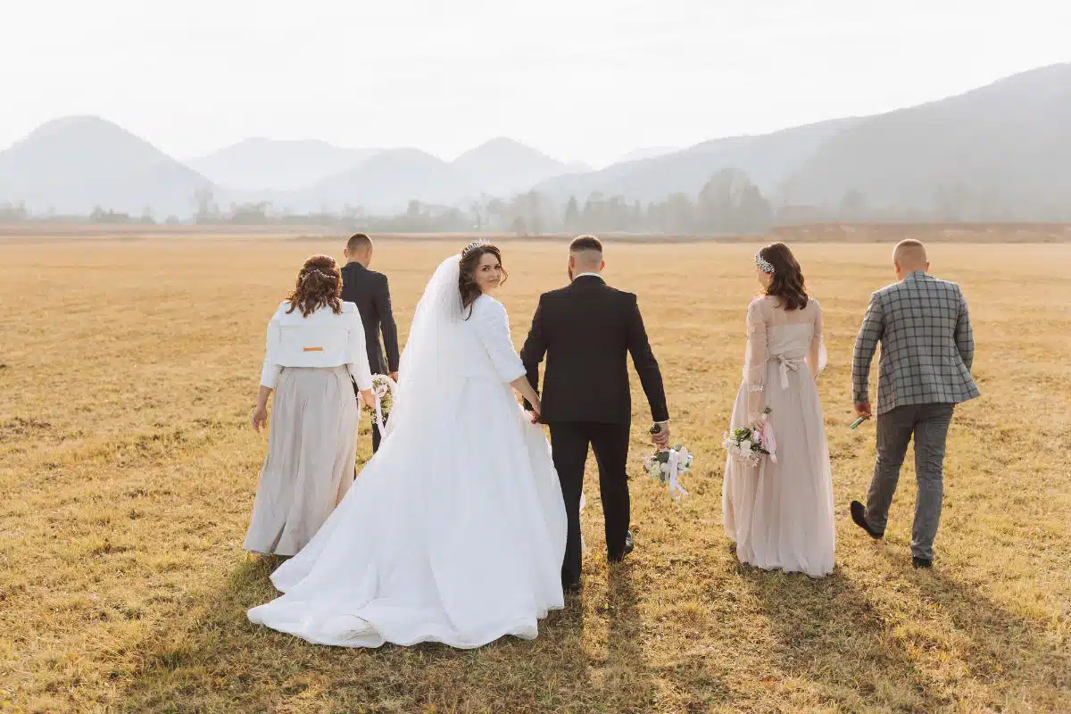 Un couple de mariés avec leurs témoins en automne